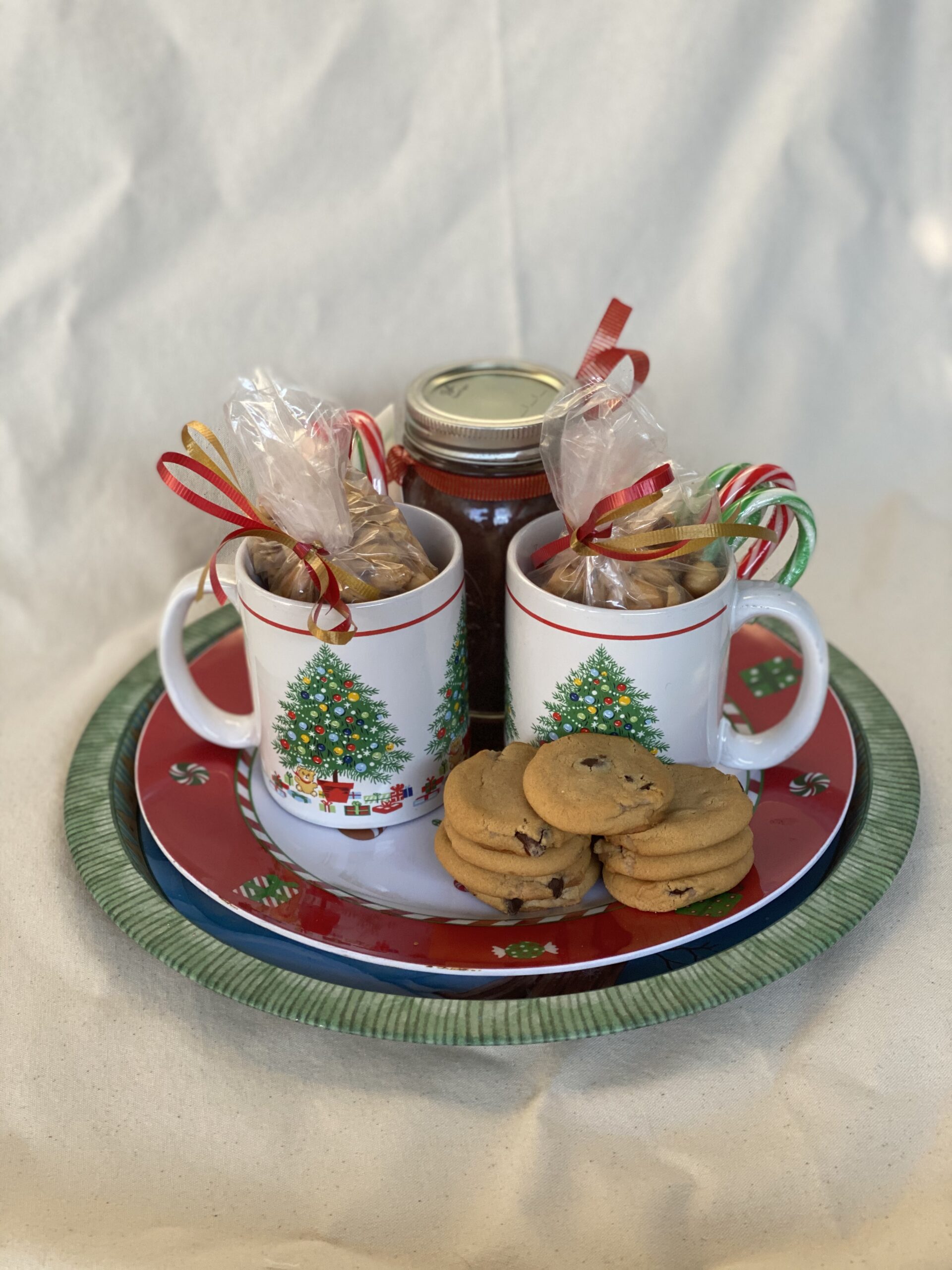 holiday plate and mugs with cookies and hot cocoa mix