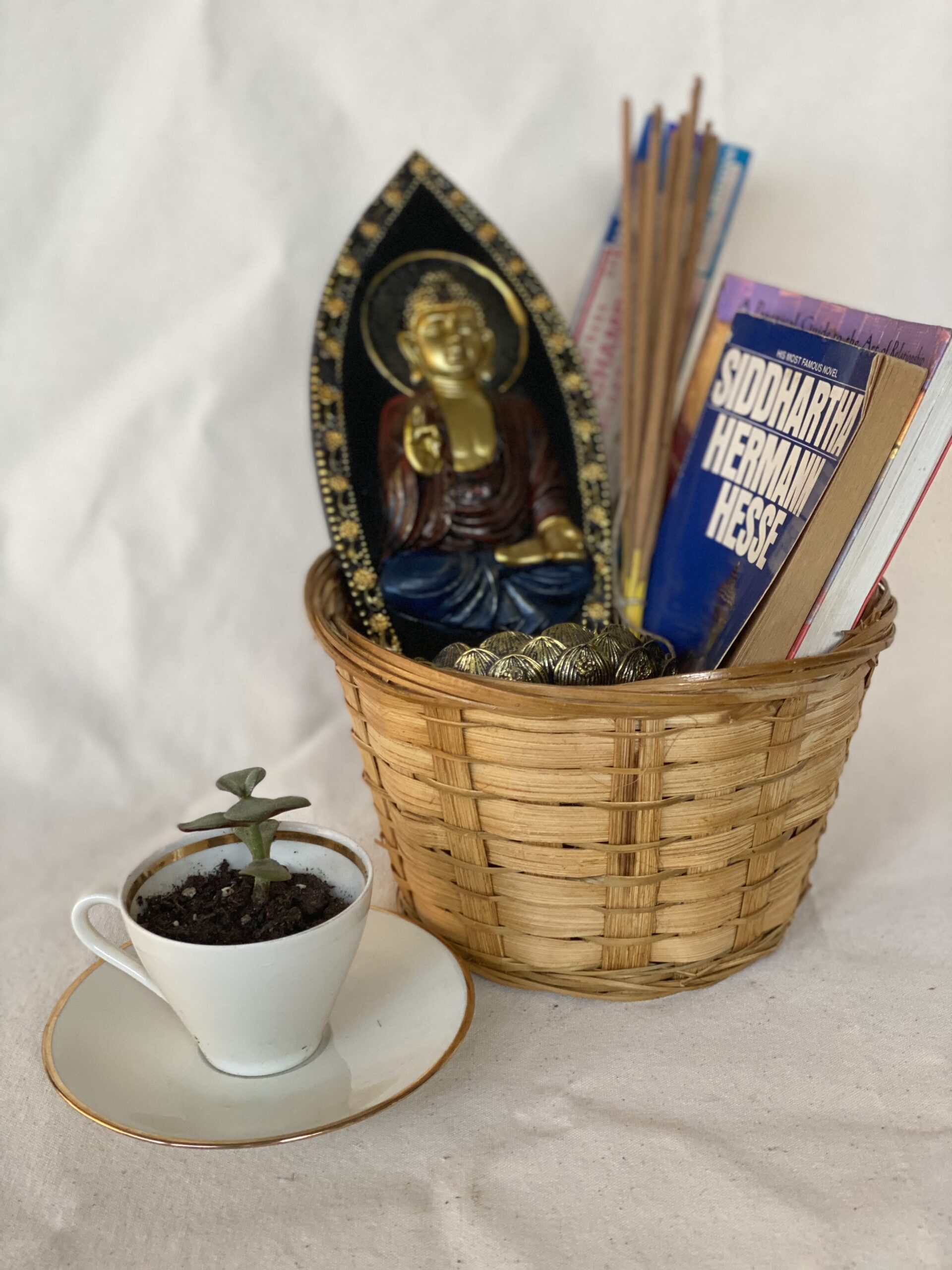gift basket with incense sticks, budda figurine, book, and a plant