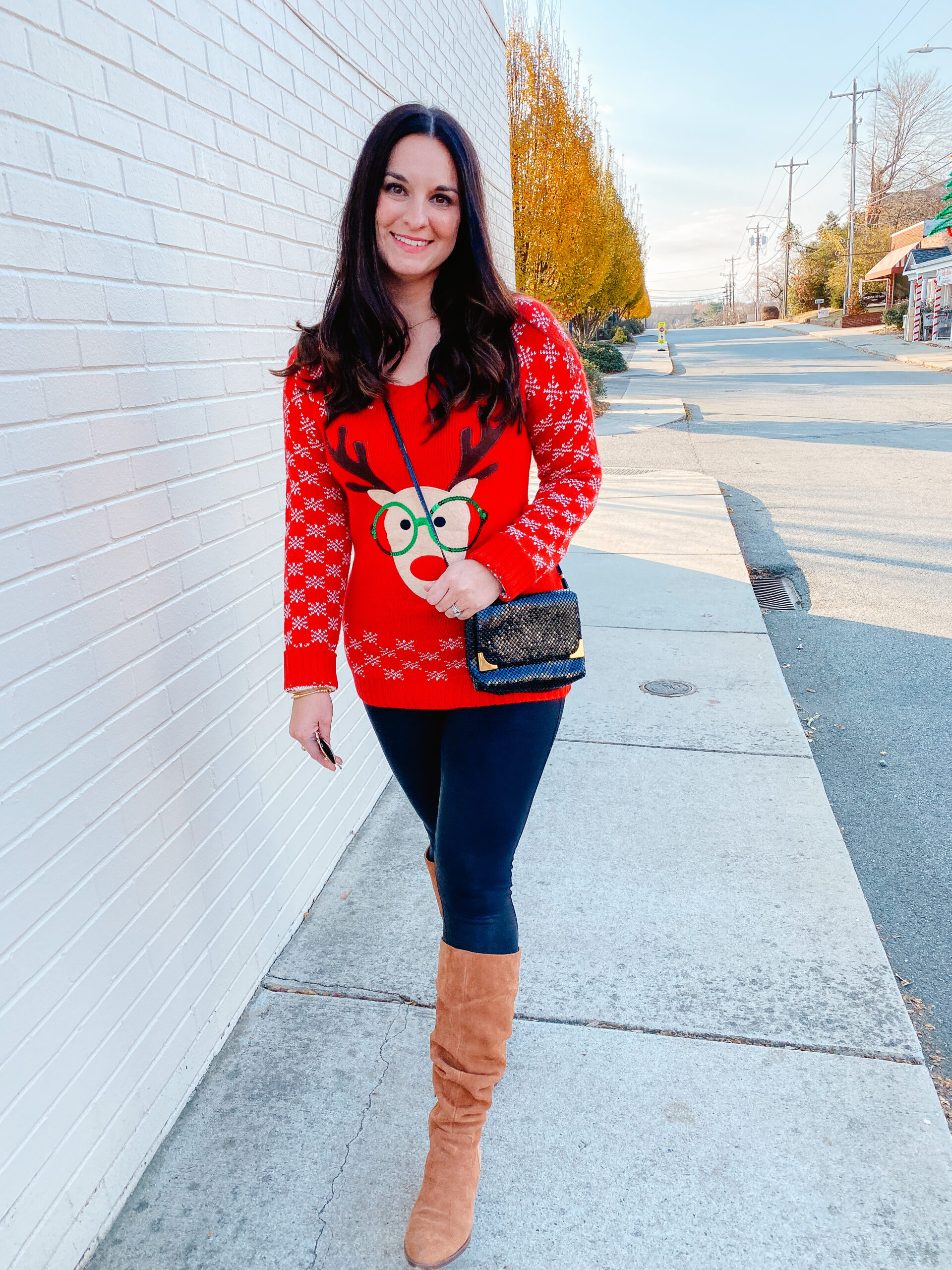 Emily Soto wearing a red holiday sweater with a silly reindeer on it